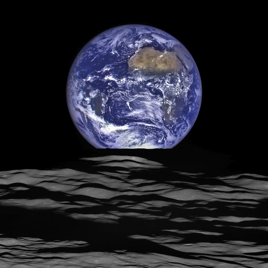 The colored image shows the blue planet earth rising above the gray-black horizon of the moon.
